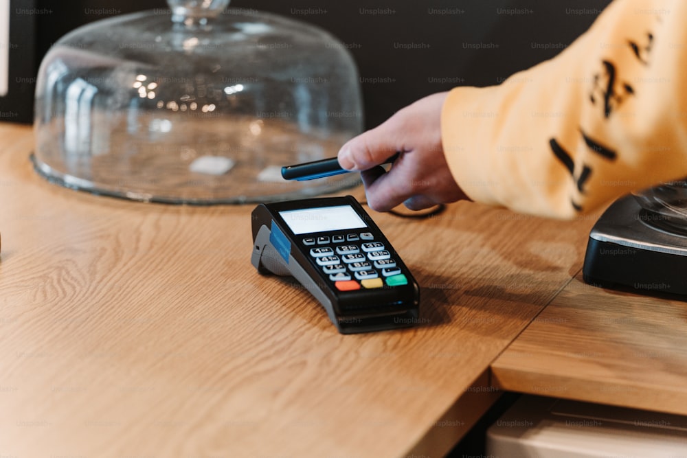 una persona usando un teléfono en una mesa de madera