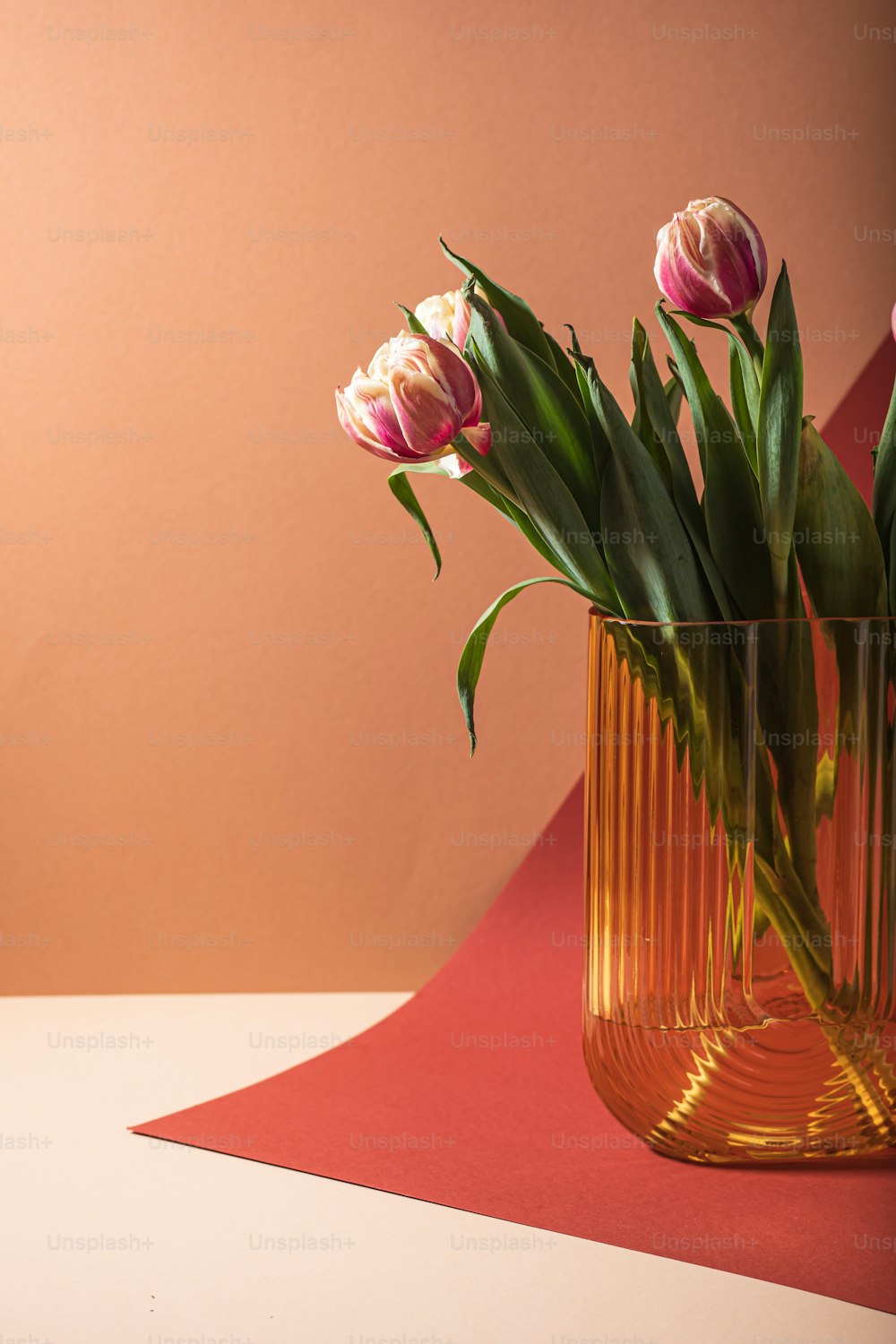 eine Vase gefüllt mit rosa Blumen auf einem Tisch