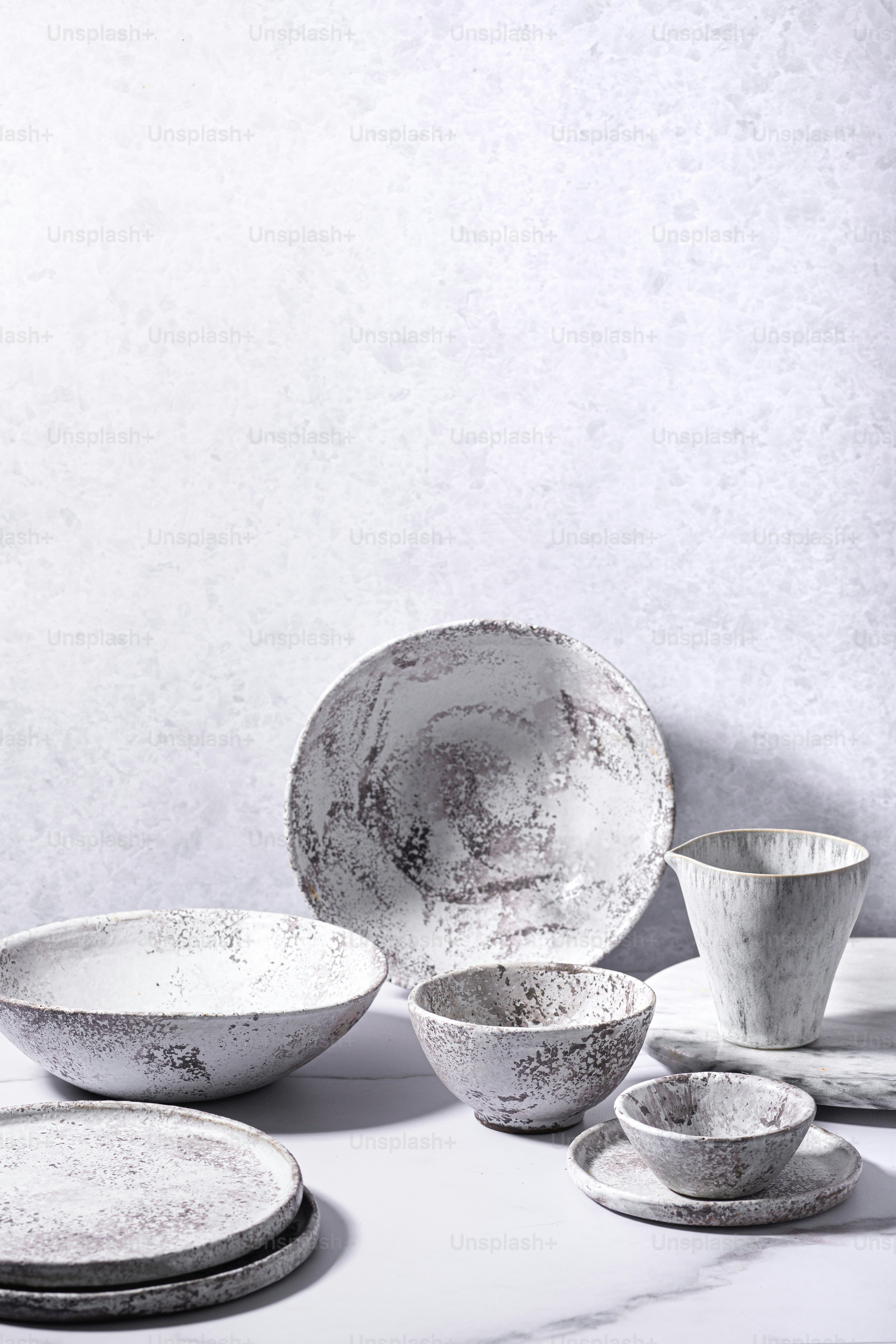 a table topped with white dishes and cups