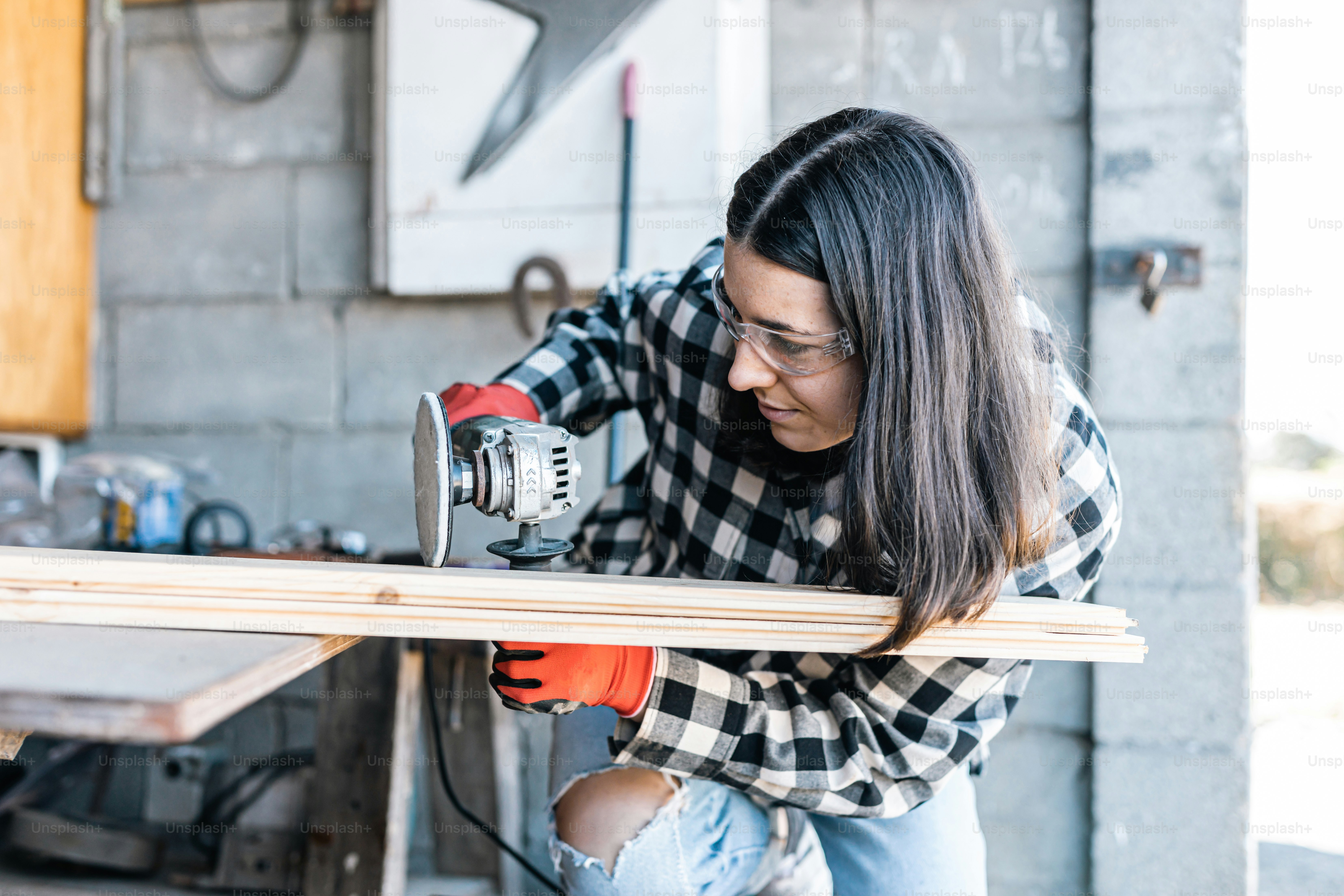 A woman is working on a piece of wood photo – Construction Image on ...