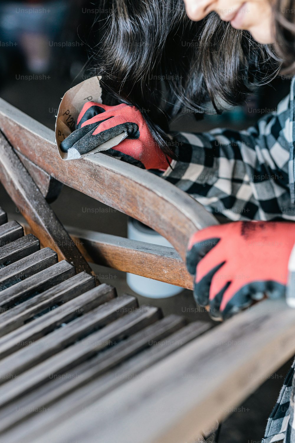 a woman is working on a wooden bench