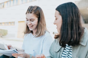 two young women sitting next to each other on a bench