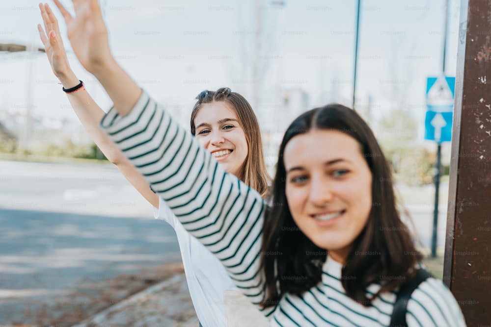 two women standing next to each other with their arms in the air