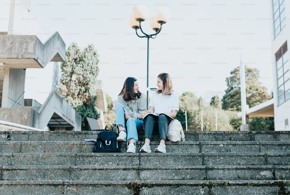 two women sitting on the steps talking to each other