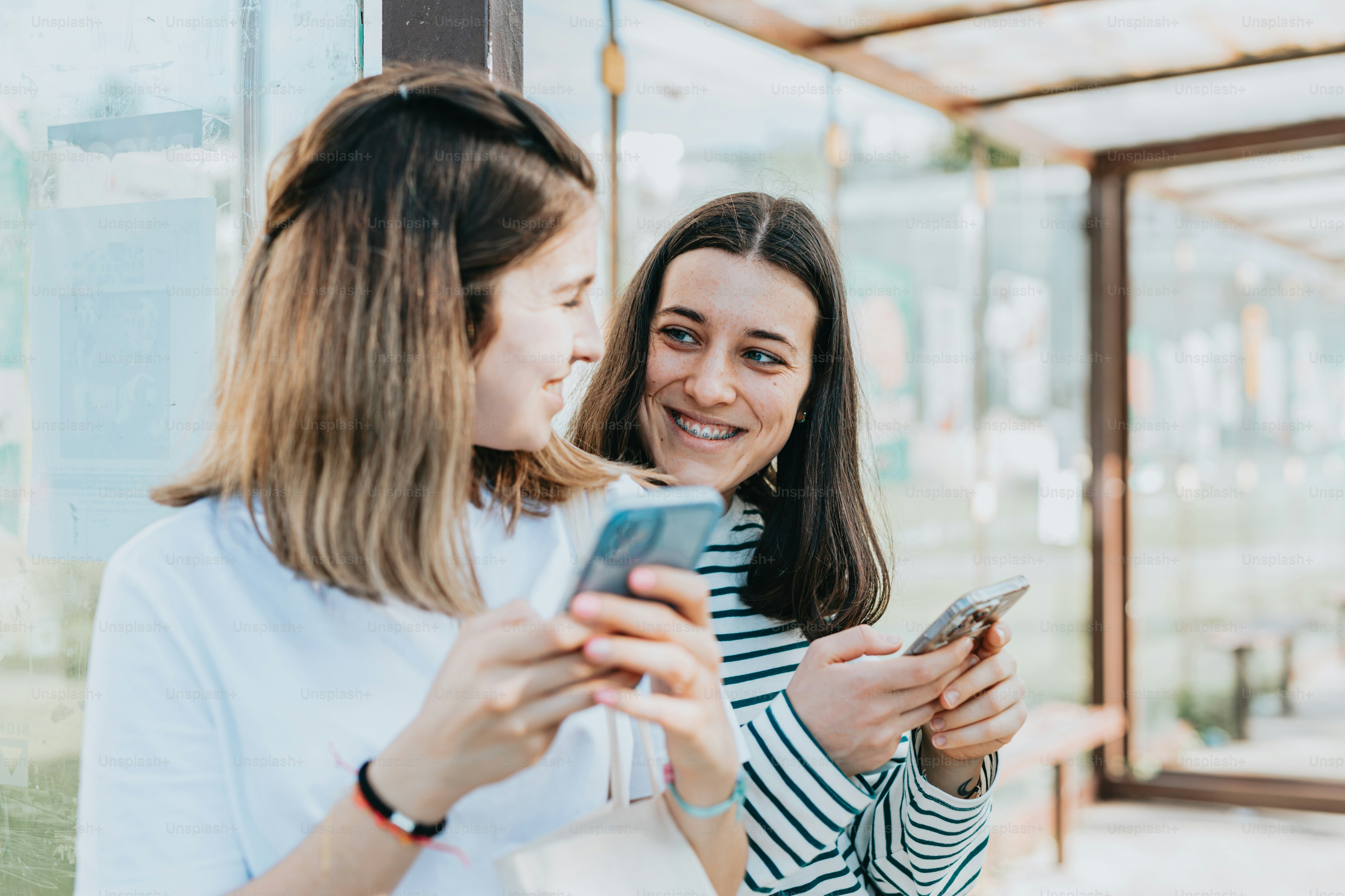 two women are looking at their cell phones