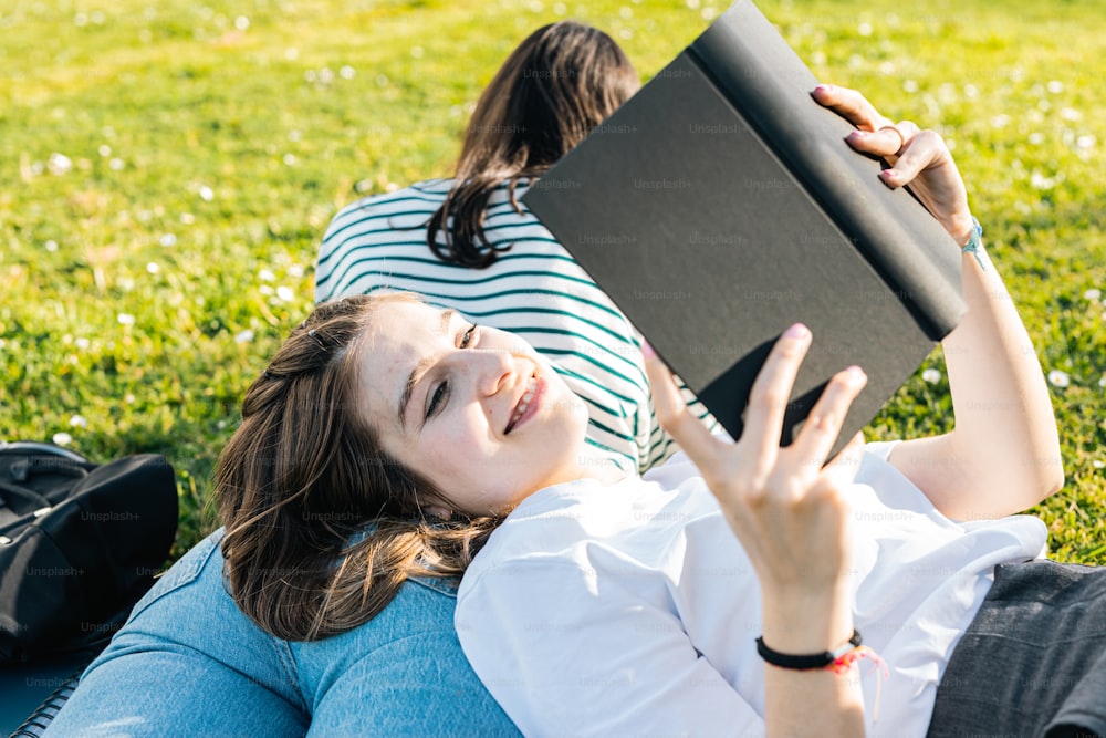 Una mujer tendida en la hierba leyendo un libro