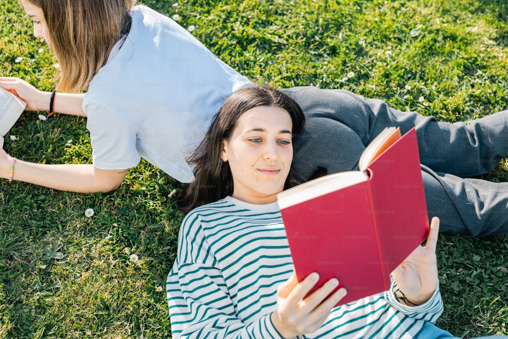 地面に横たわって本を読む女性