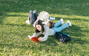 Une femme allongée sur l’herbe en train de lire un livre