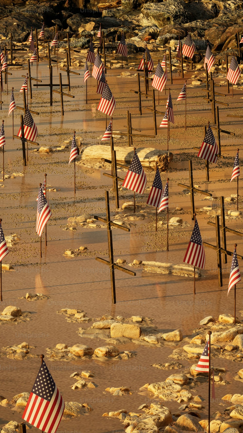 Ein Haufen amerikanischer Flaggen, die im Sand liegen