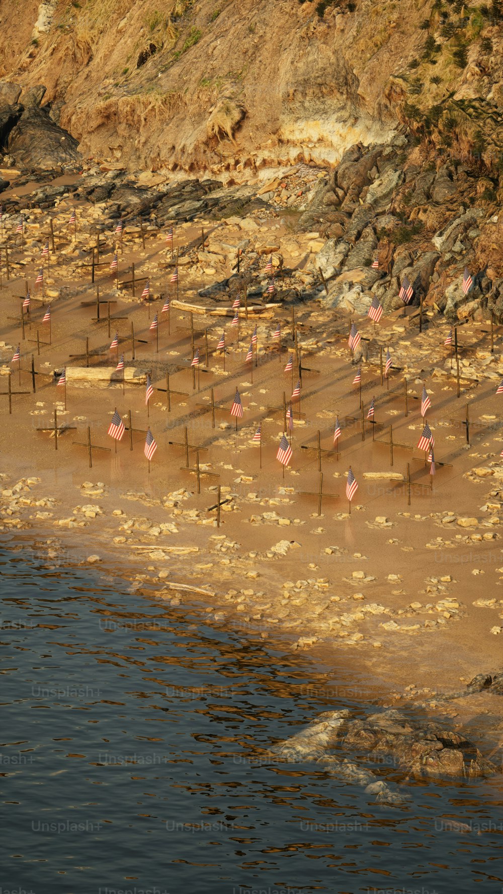 a flock of flamingos standing on top of a sandy beach