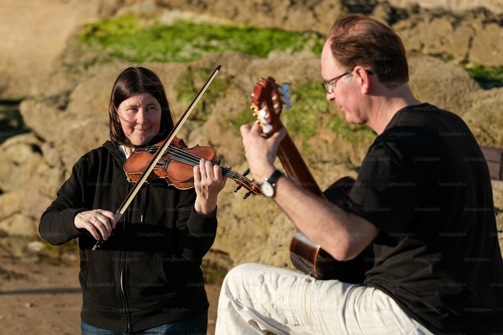 女性の隣でバイオリンを弾く男性