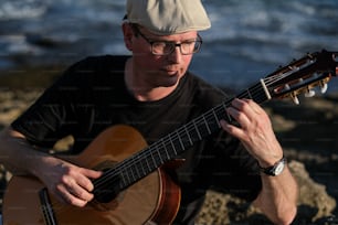 um homem que toca uma guitarra na praia