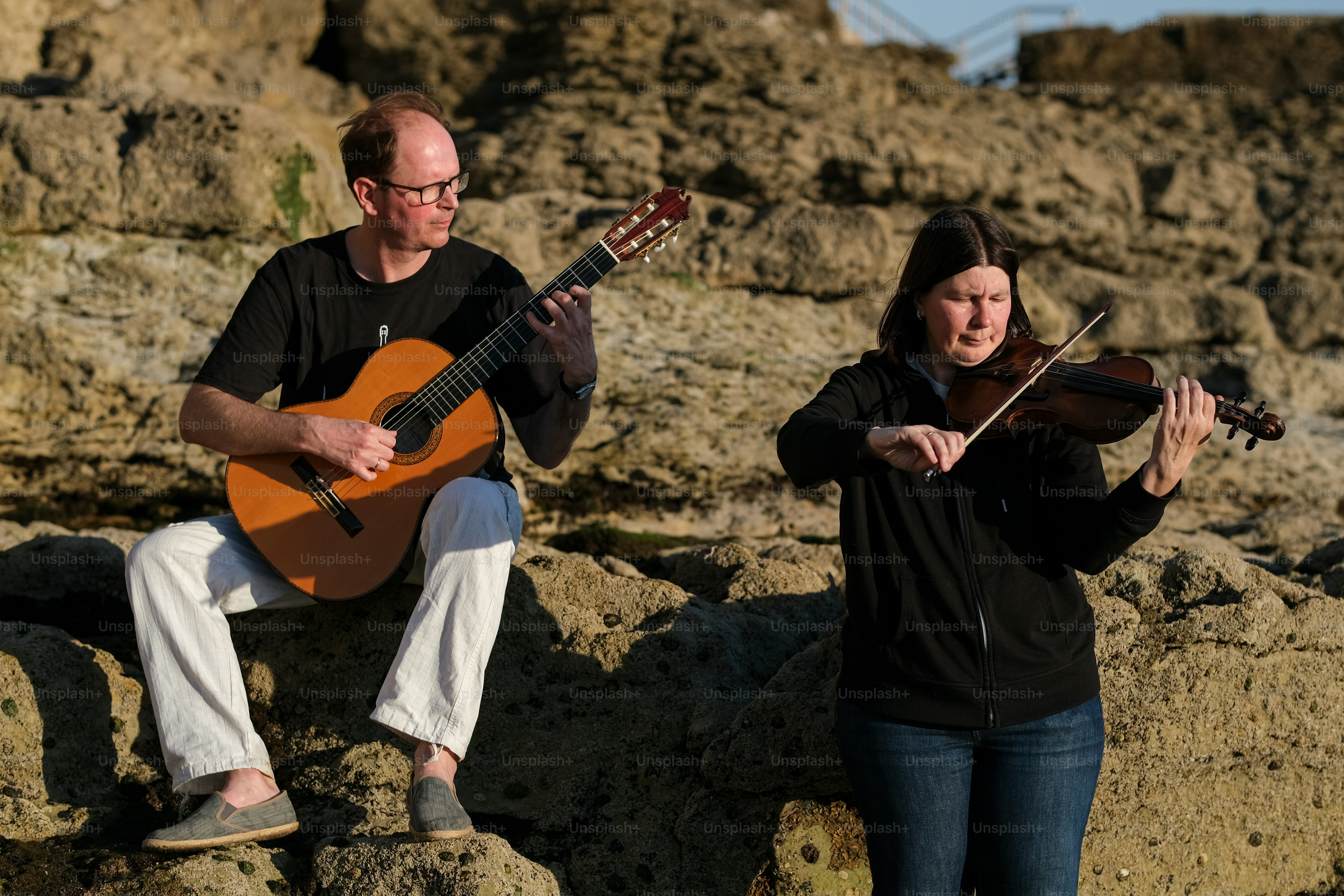 a man playing a violin and a woman playing a violin