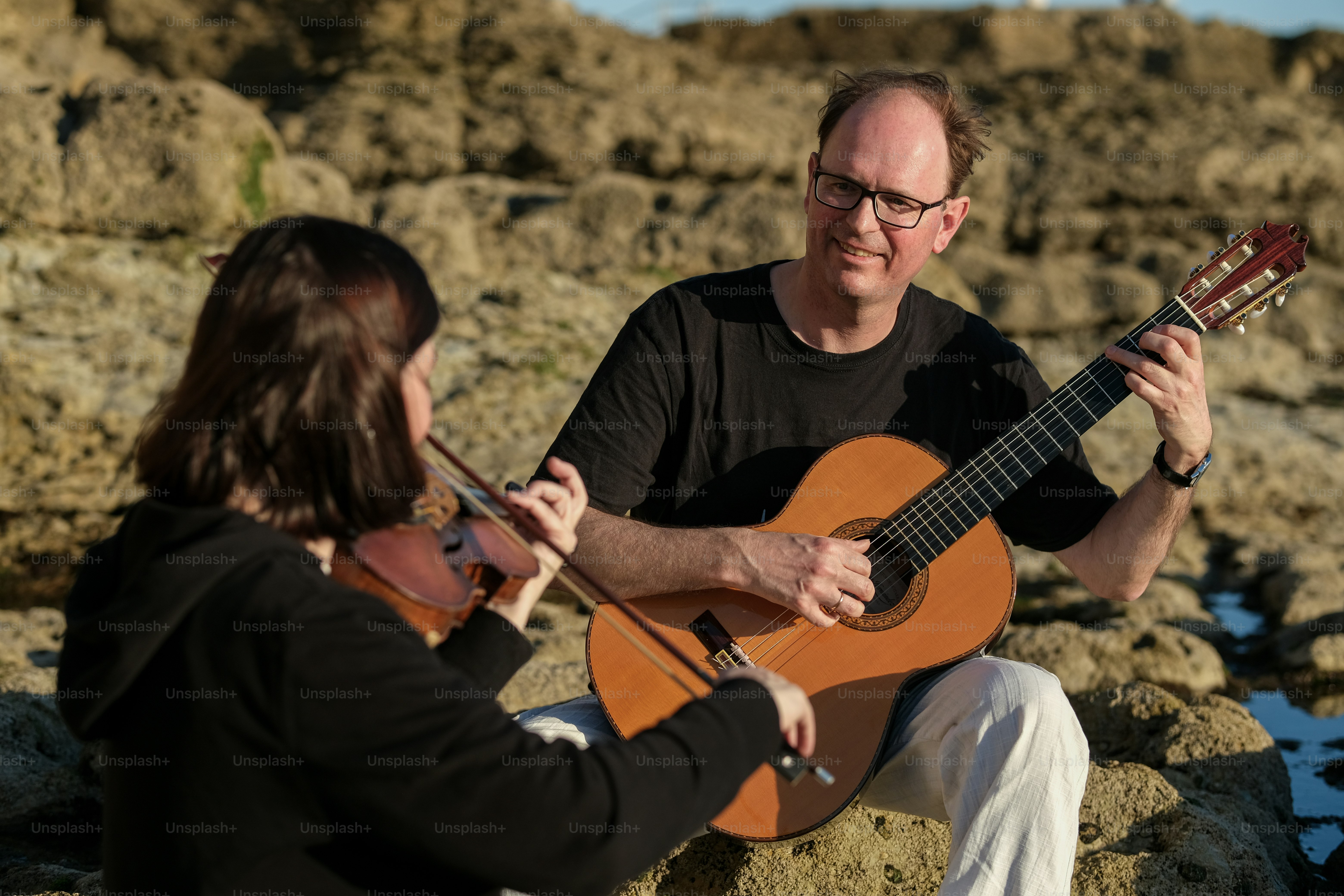 a man playing a guitar with a woman