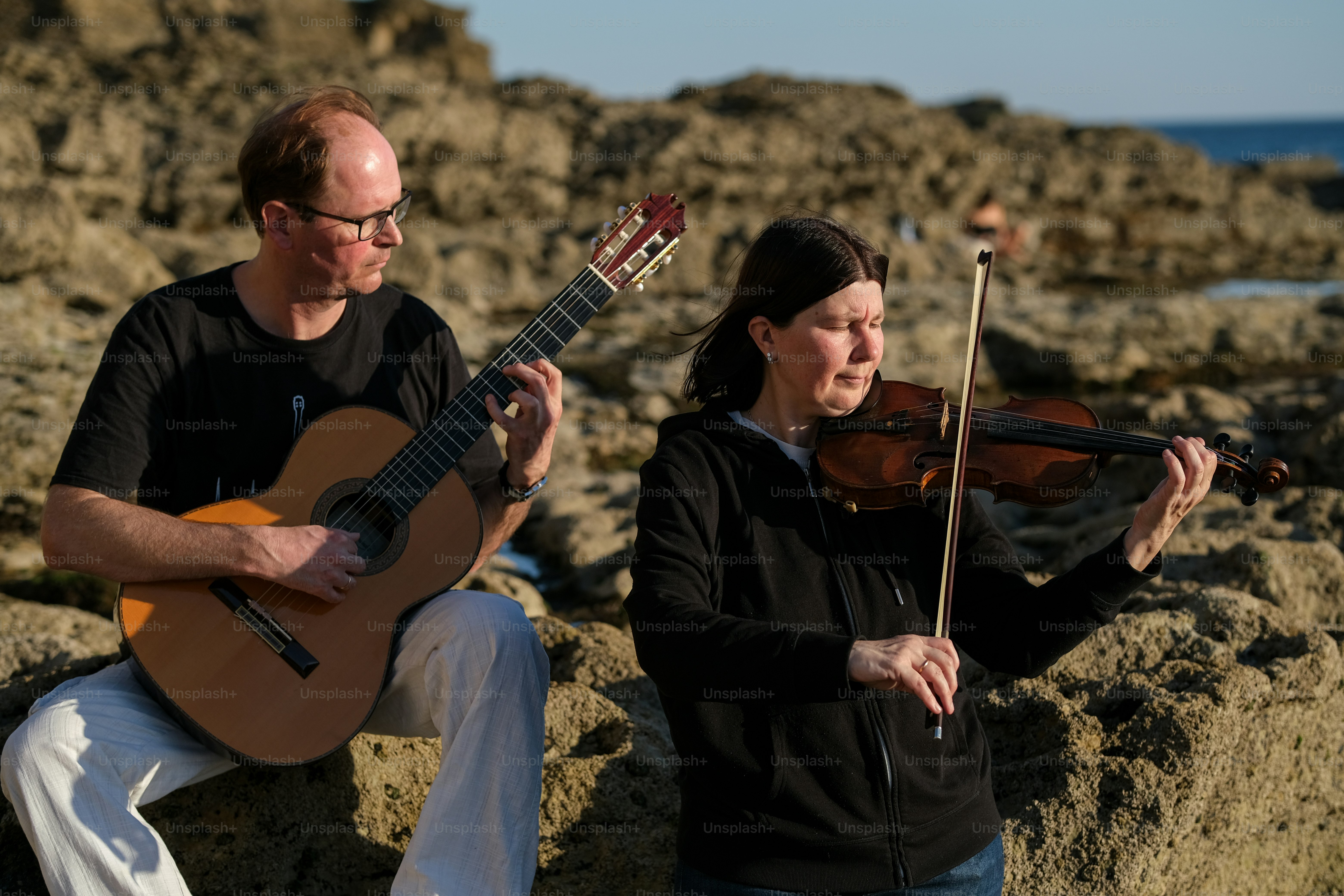a man playing a violin and a woman playing a violin