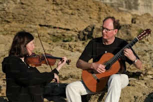 Un hombre tocando un violín junto a una mujer