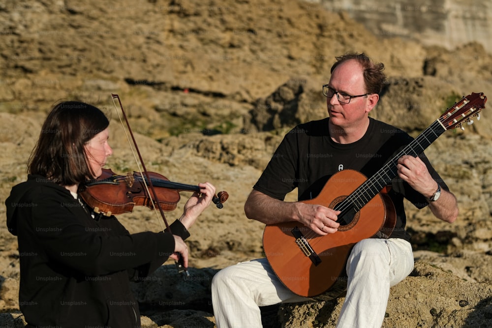 a man playing a violin next to a woman