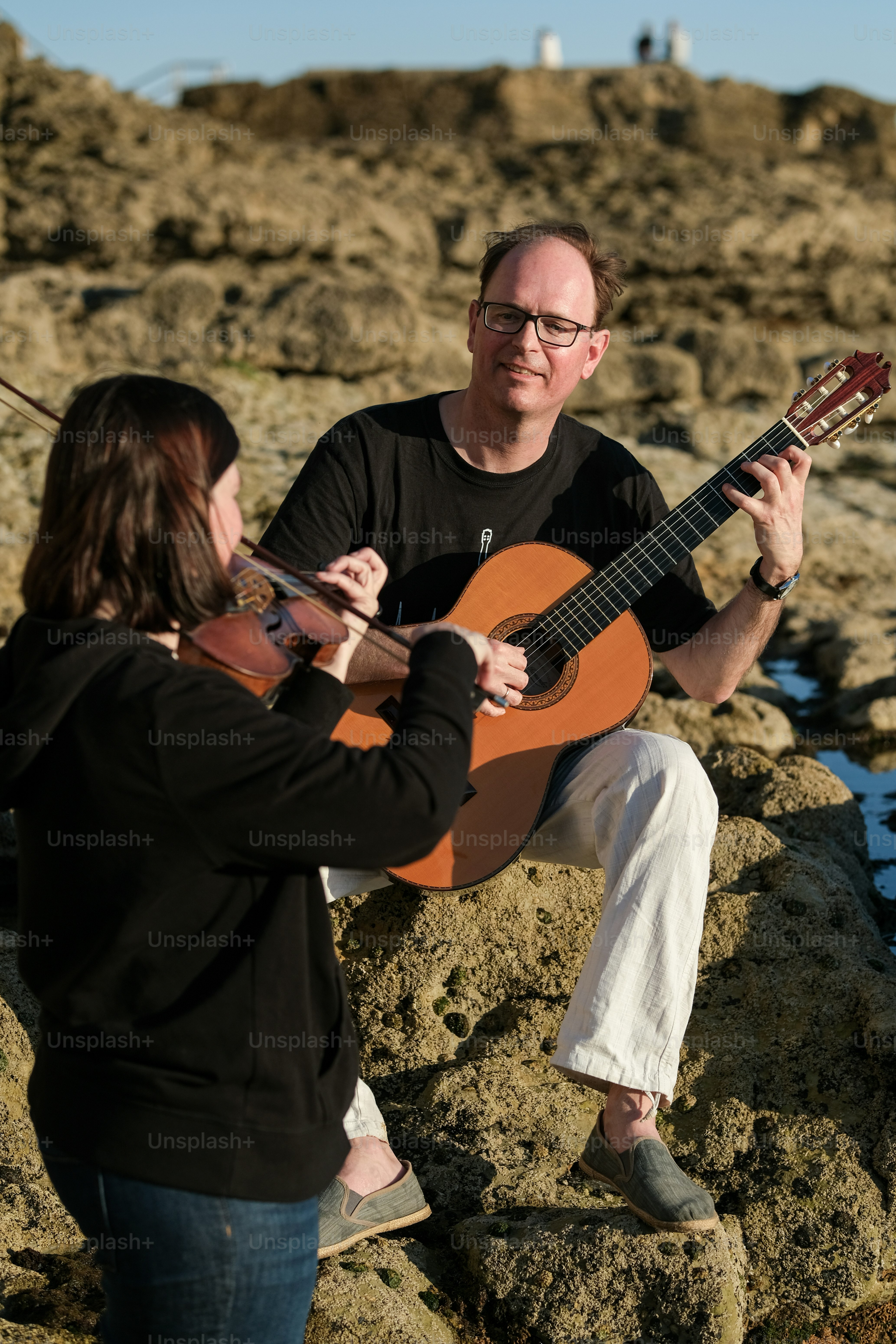 a man playing a guitar with a woman