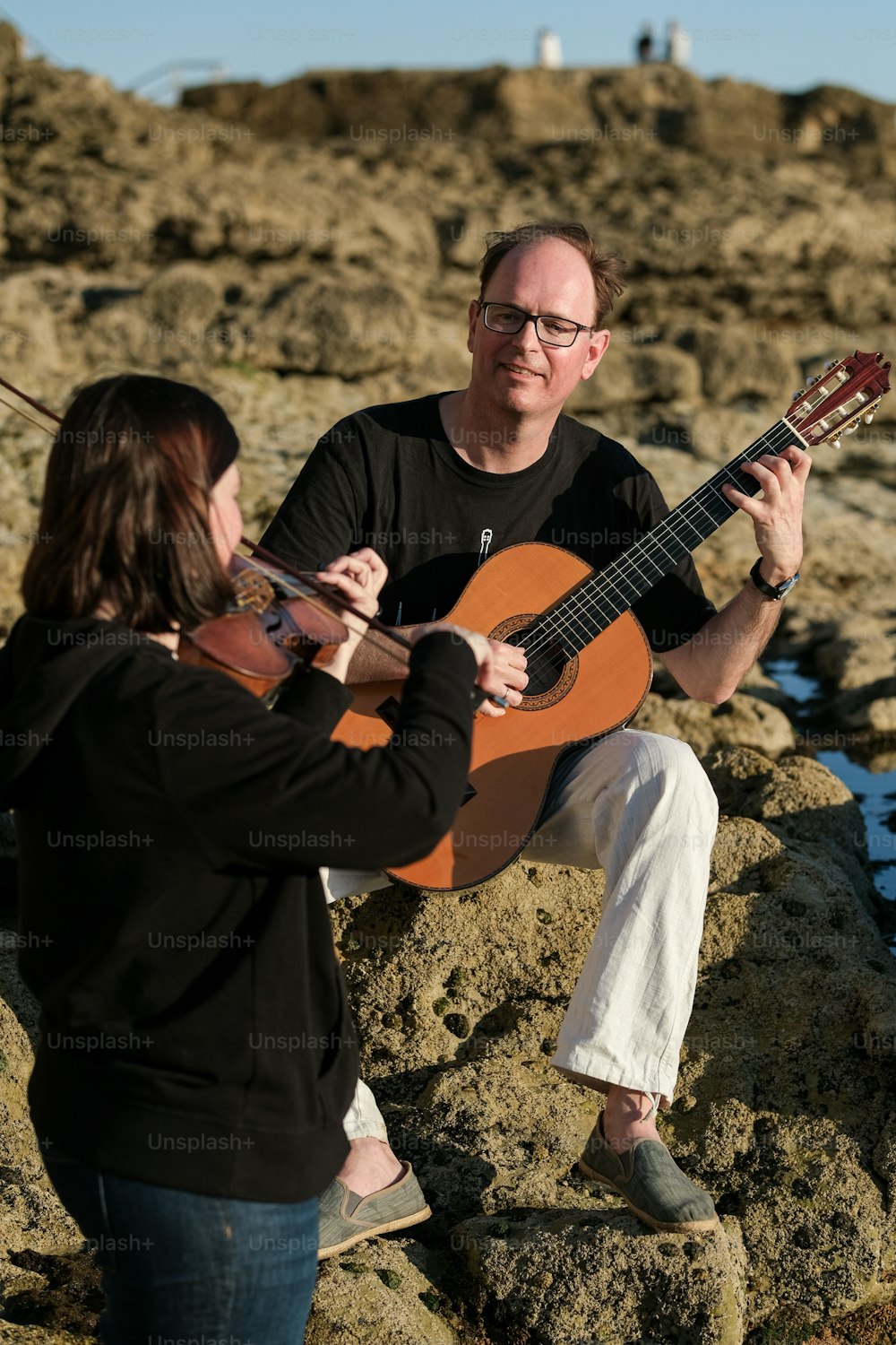 a man playing a guitar with a woman