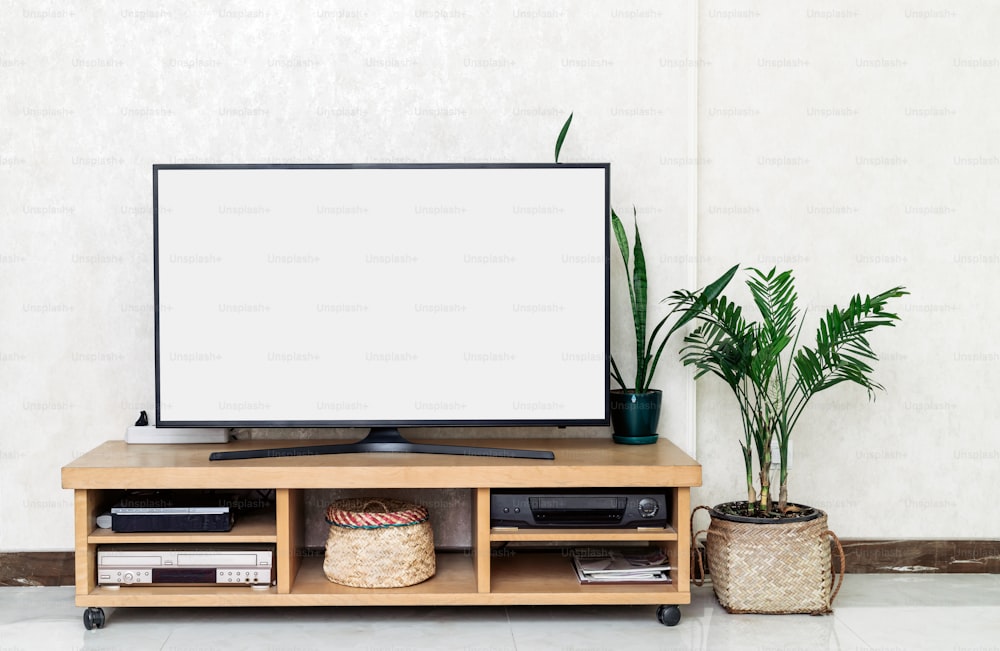 uma TV de tela plana sentada em cima de um suporte de madeira