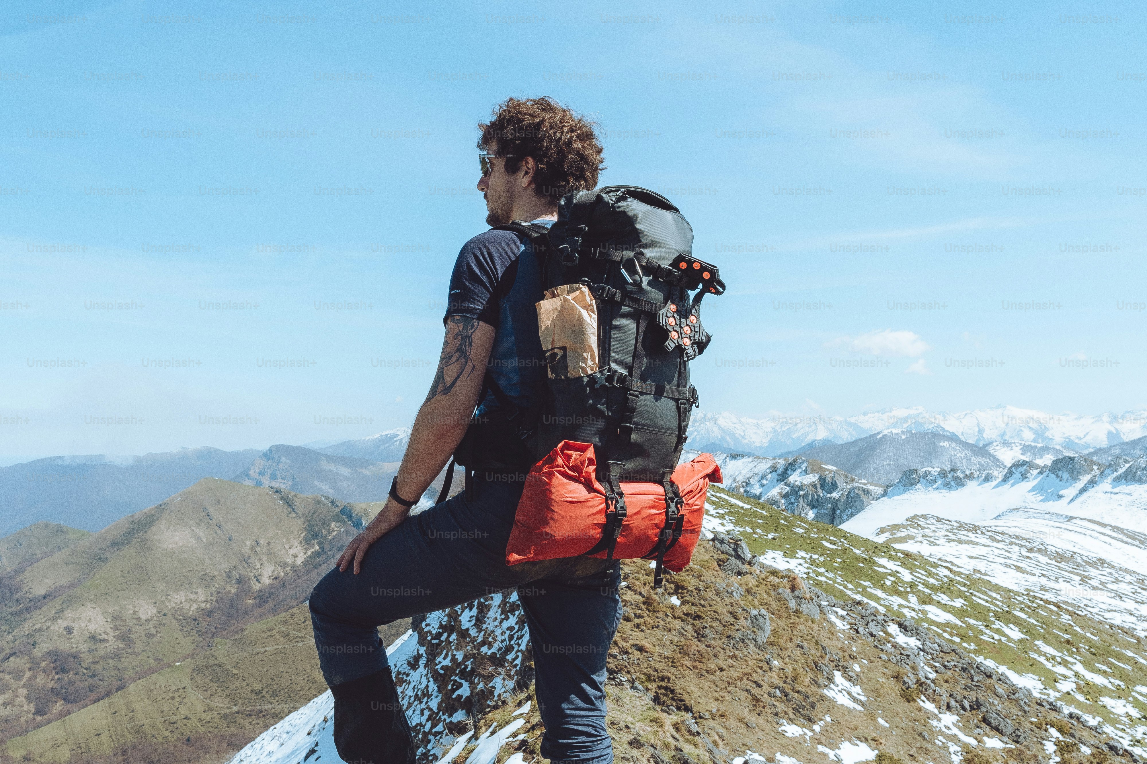a man with a backpack on top of a mountain