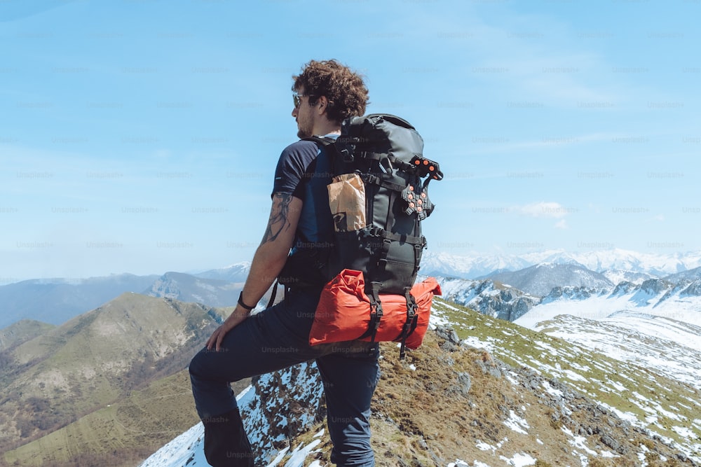 a man with a backpack on top of a mountain