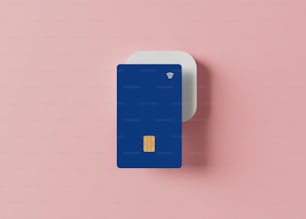eine blaue Kreditkarte, die auf einer rosa Oberfläche sitzt