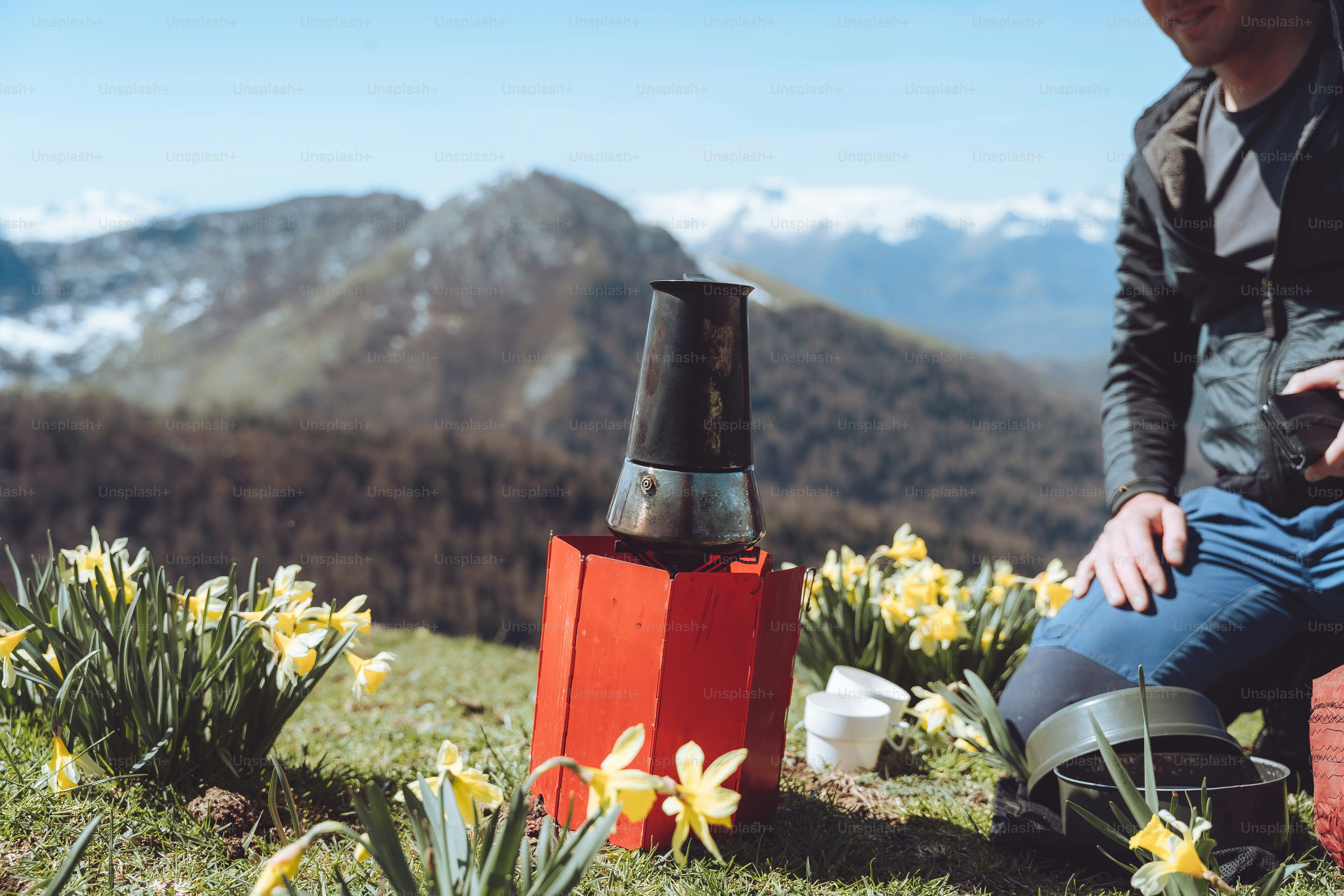 a man sitting on top of a lush green hillside