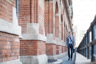 Handsome mature businessman walking in a city.