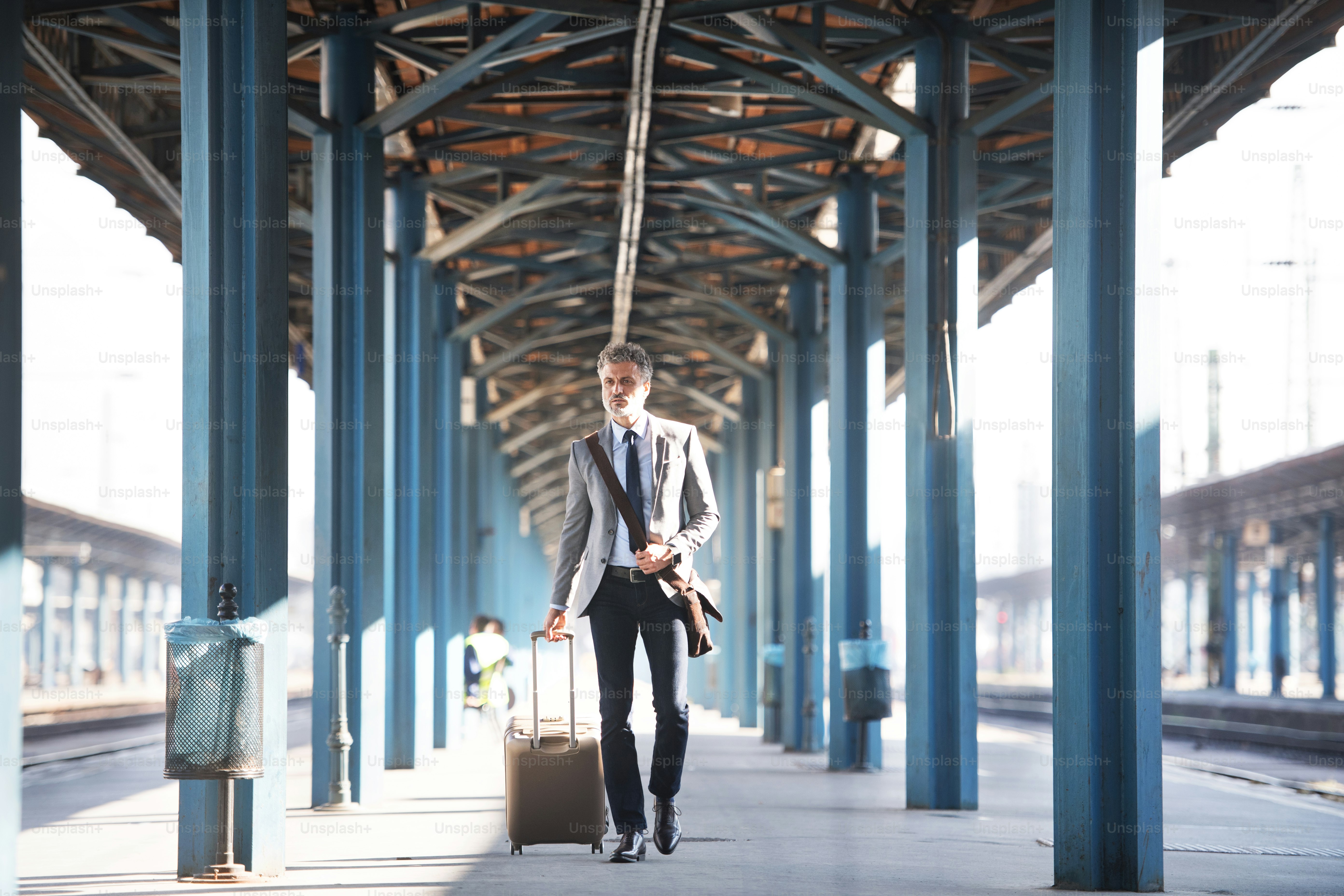 Handsome mature businessman in a city. Man walking on the railway ...