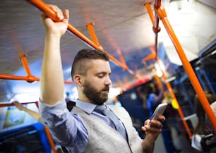 Bel homme moderne hipster appelant par téléphone portable dans le tram la nuit