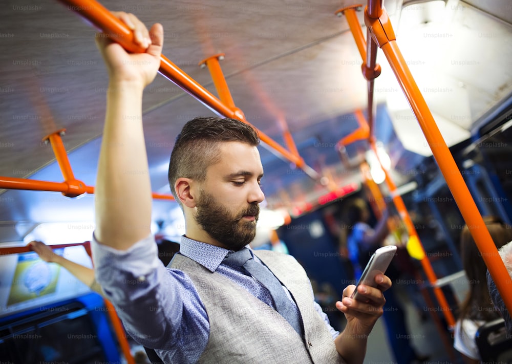 Guapo hombre moderno hipster llamando por teléfono móvil en tranvía por la noche