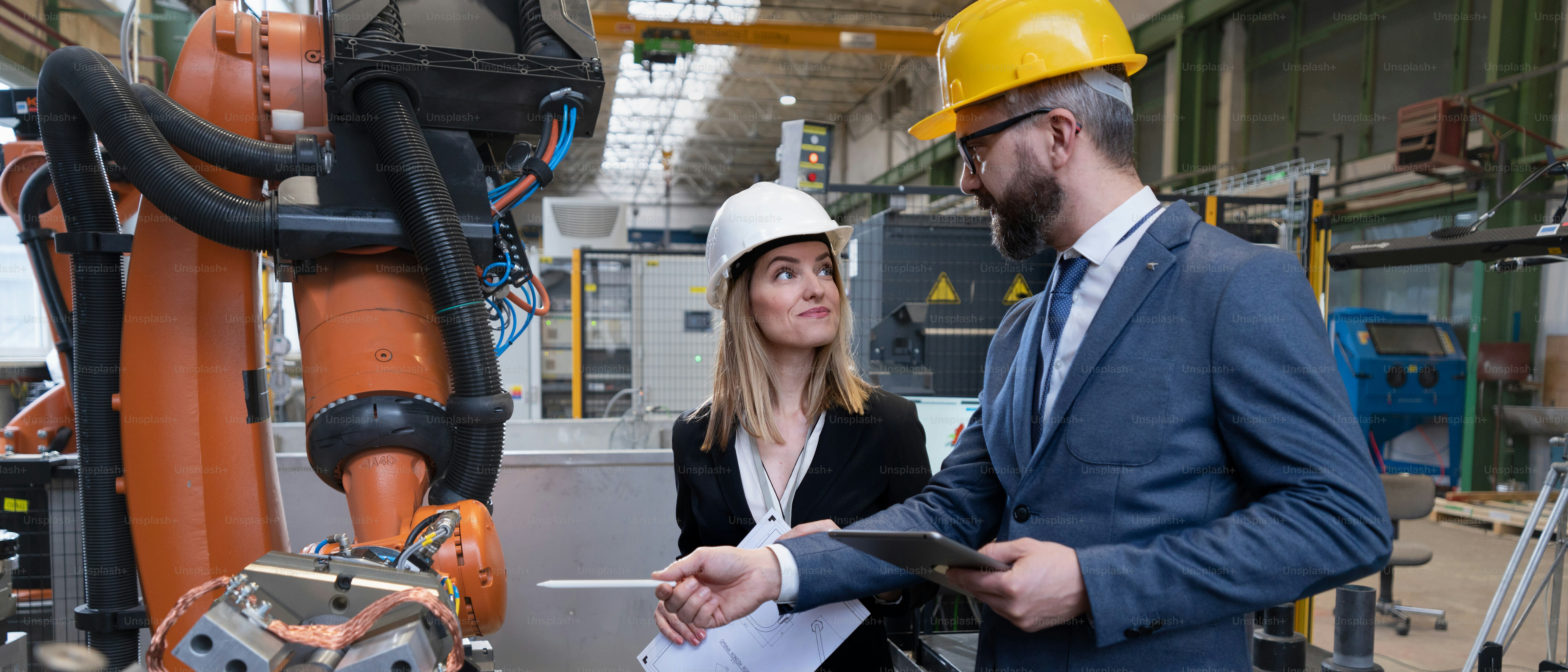 A top view of engineer and industrial worker in uniform shaking hands ...