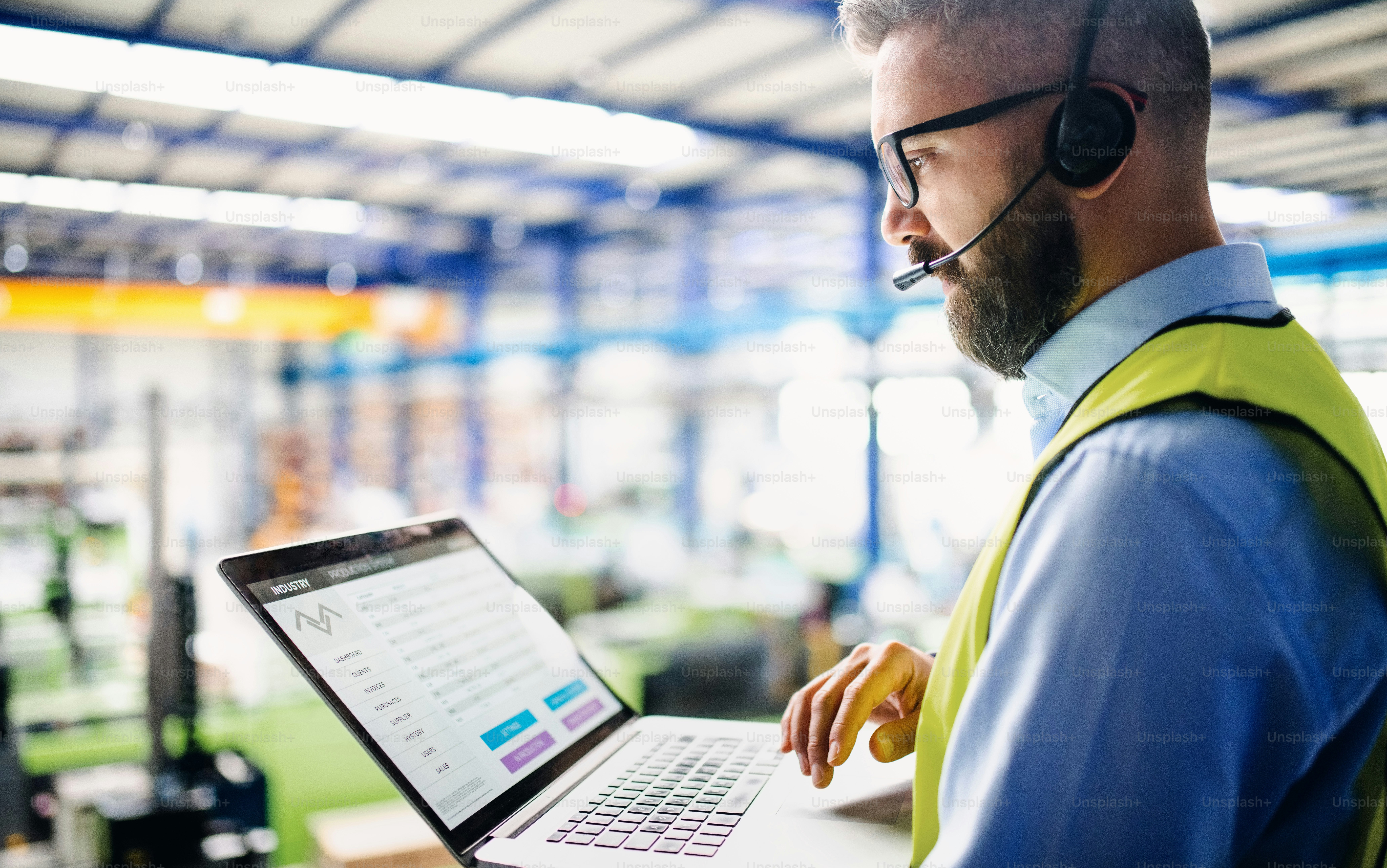 Managers reviewing cloud based RFID inventory software dashboards across multiple warehouses