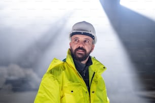 Front view of man engineer standing on construction site.