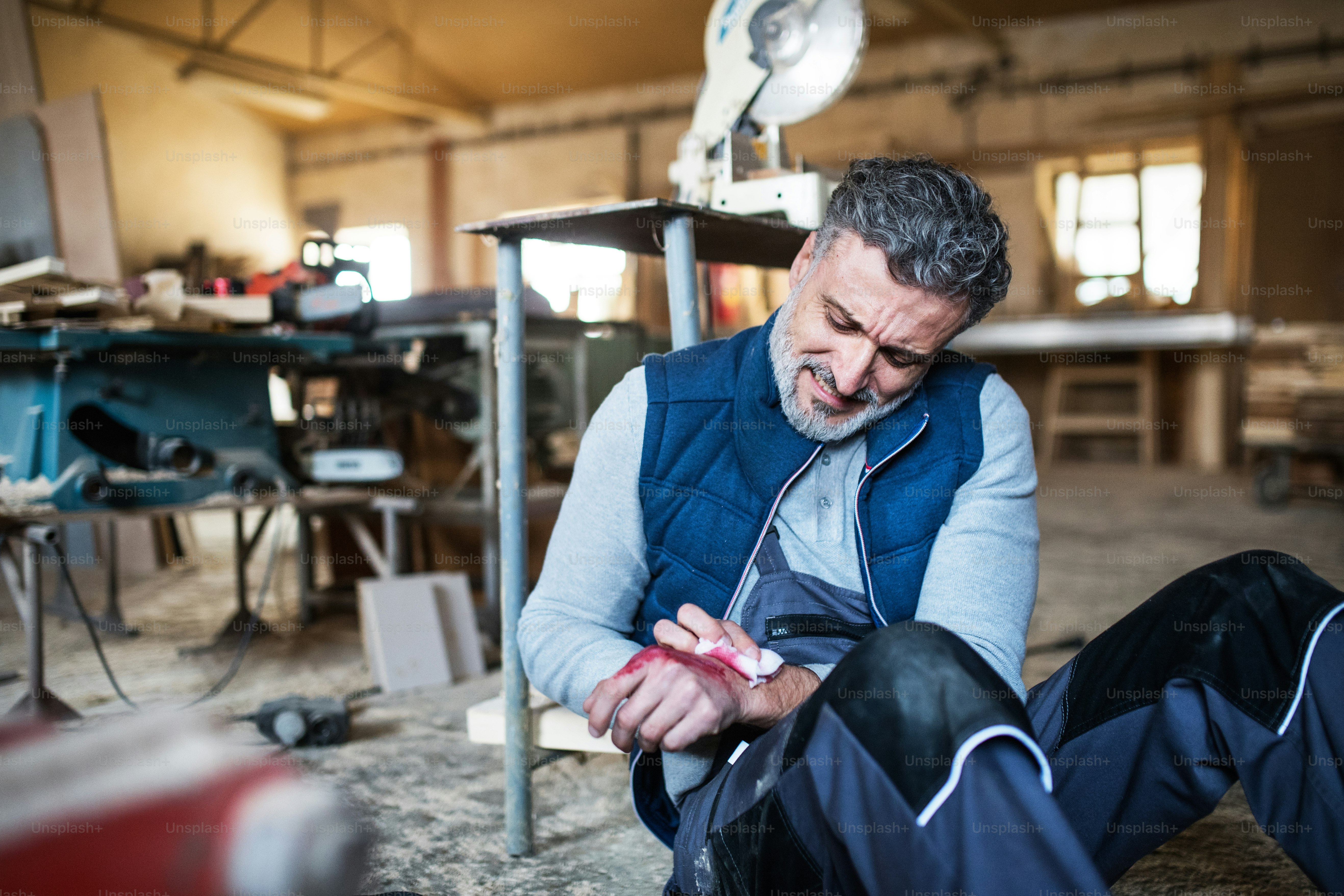 Ein Arbeiter in der Schreinerei mit einer verletzten Hand. Arbeitsunfall.