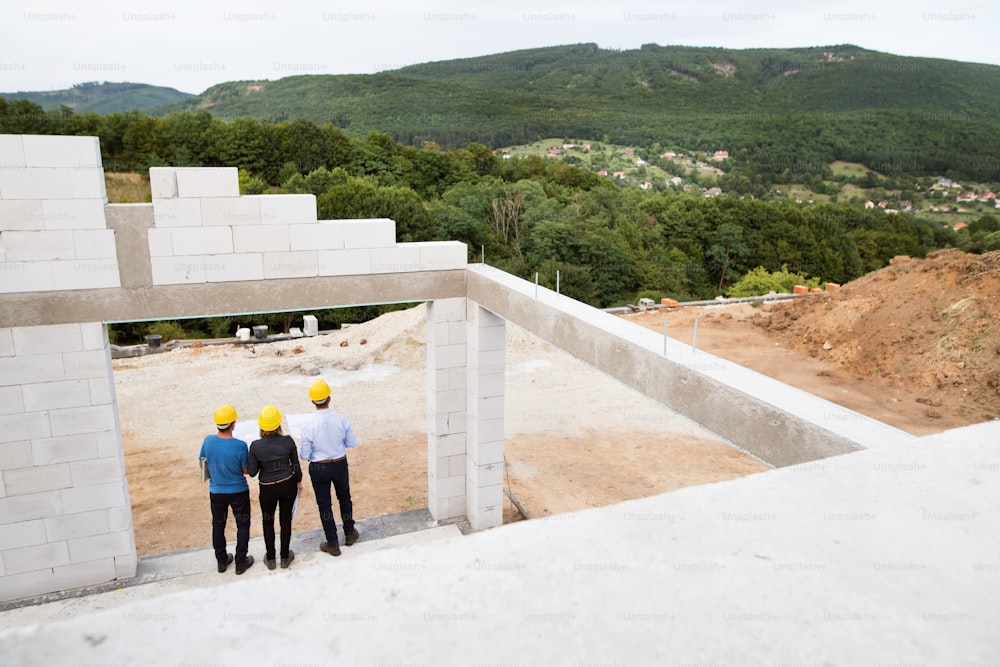 Architect, civil engineer and worker discussing issues at the construction site.