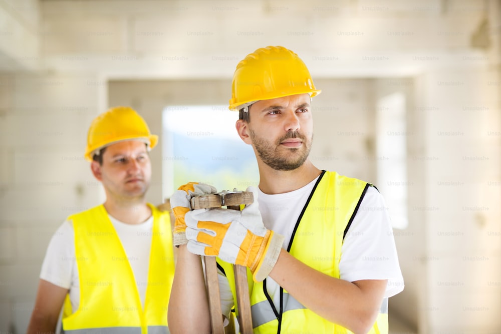 Construction workers collaborating on new house building