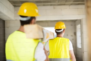 Construction workers collaborating on new house building