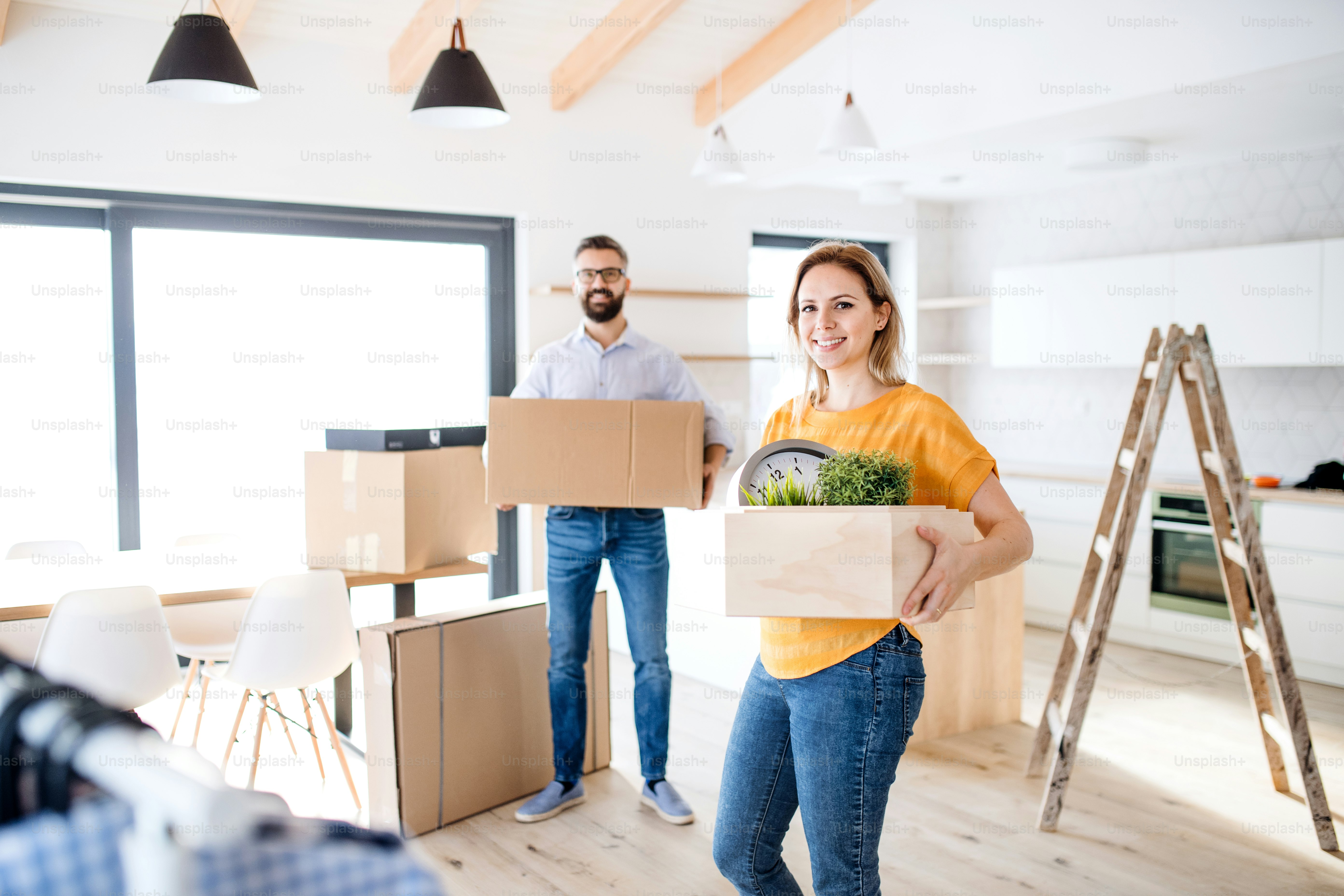 A young happy couple furnishing new house, a moving in new home concept ...