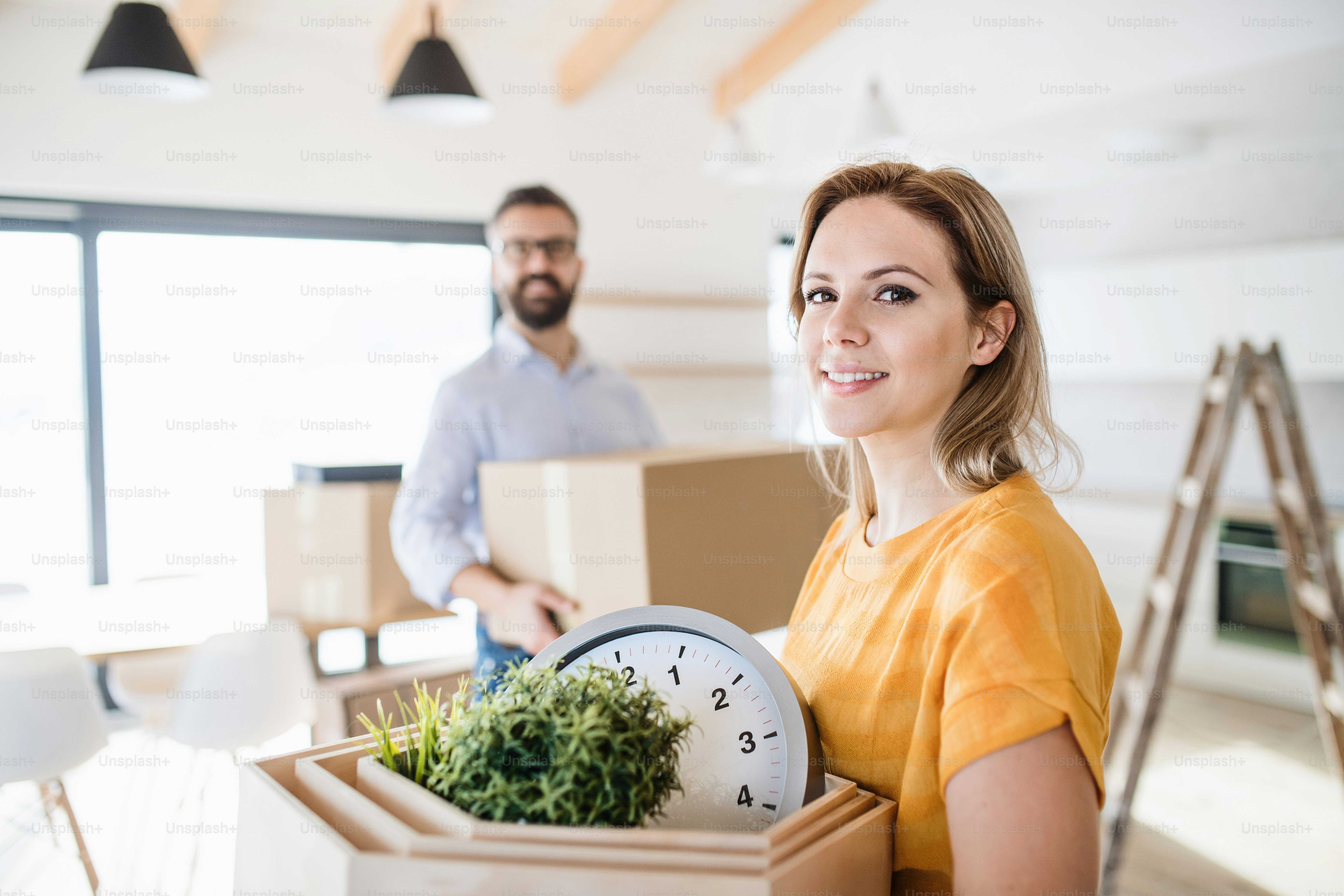 A young happy couple furnishing new house, a moving in new home concept ...