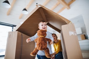 Un portrait d’une jeune famille heureuse avec une petite fille, emménageant dans un nouveau concept de maison.