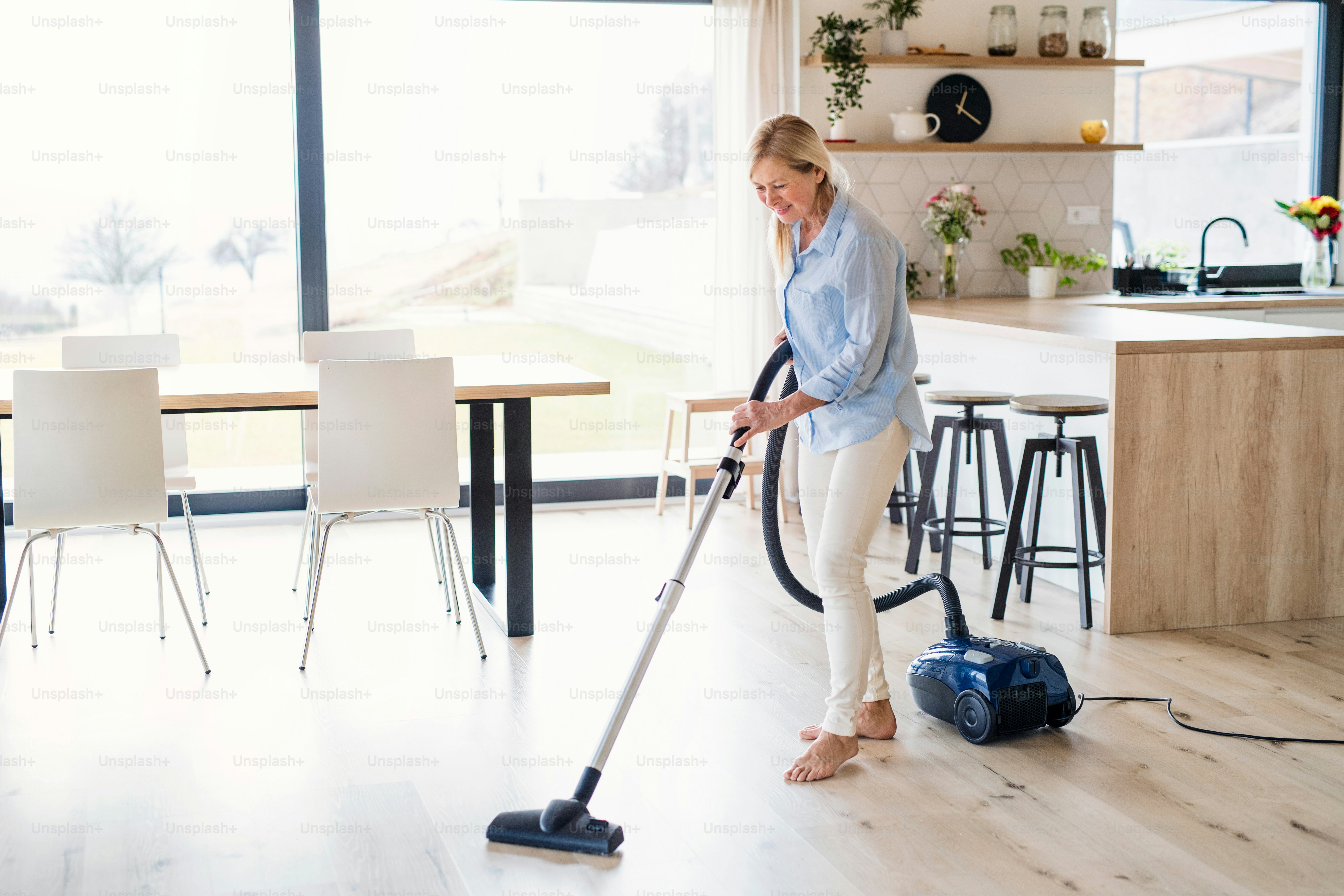 Homeowner using steam cleaners on a kitchen floor during routine cleani
