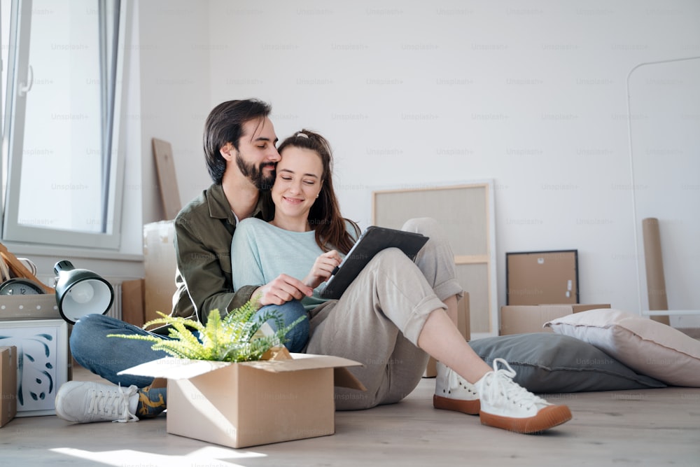 Jeune couple heureux avec des boîtes emménageant dans un nouvel appartement, une nouvelle maison et un concept de relocalisation.