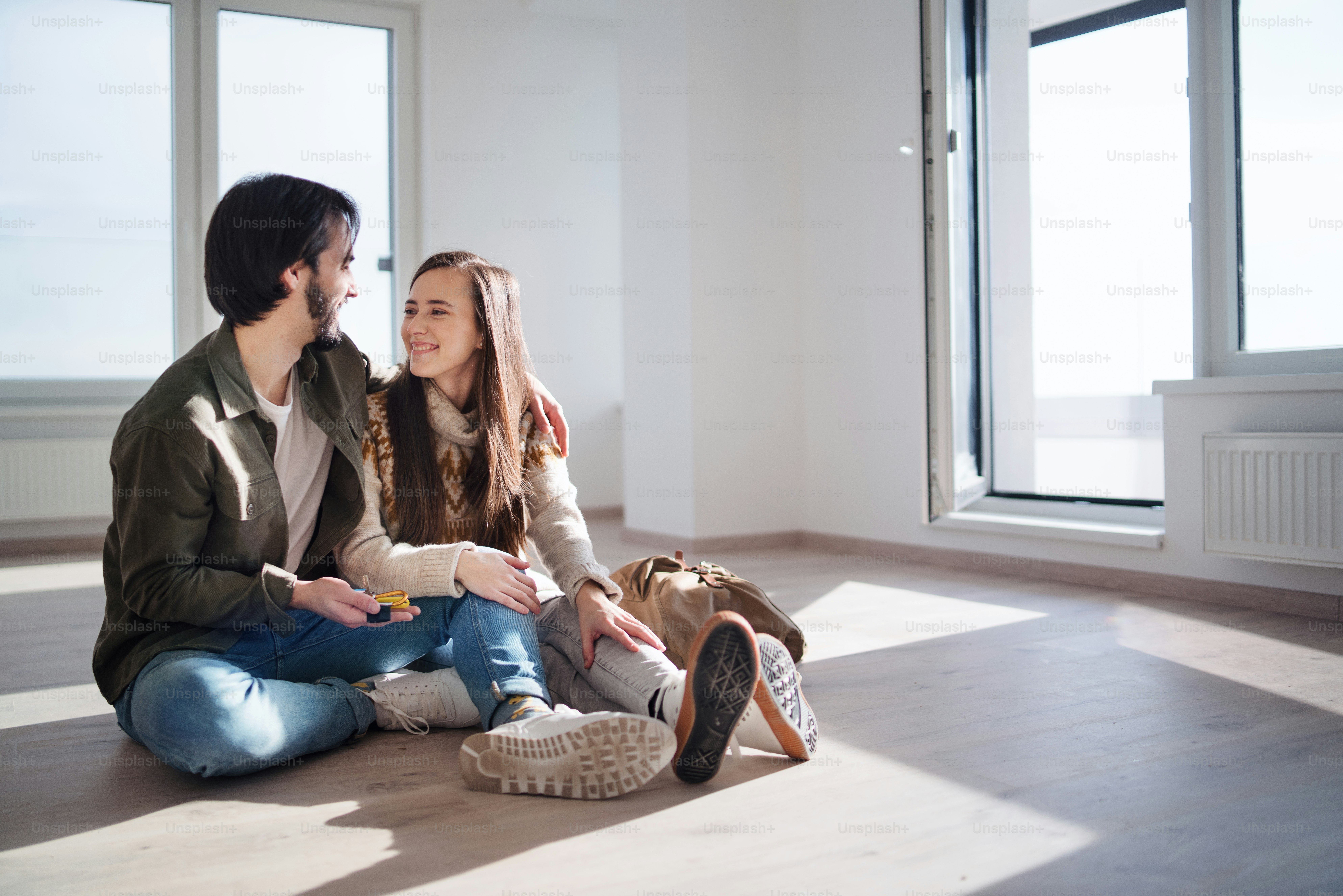 Jeune couple heureux avec les clés emménageant dans un nouvel appartement, nouvelle maison et concept de relocalisation.