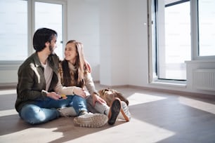 Happy young couple with keys moving in new flat, new home and relocation concept.