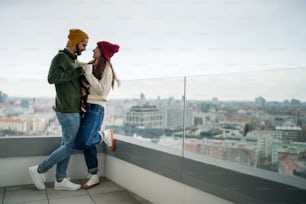 Giovani proprietari di coppie felici con caffè sul balcone in un nuovo appartamento, trasloco, nuova casa e concetto di trasferimento.