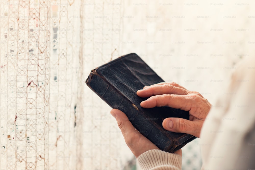 Nicht wiederzuerkennende Frau, die eine Bibel in den Händen hält