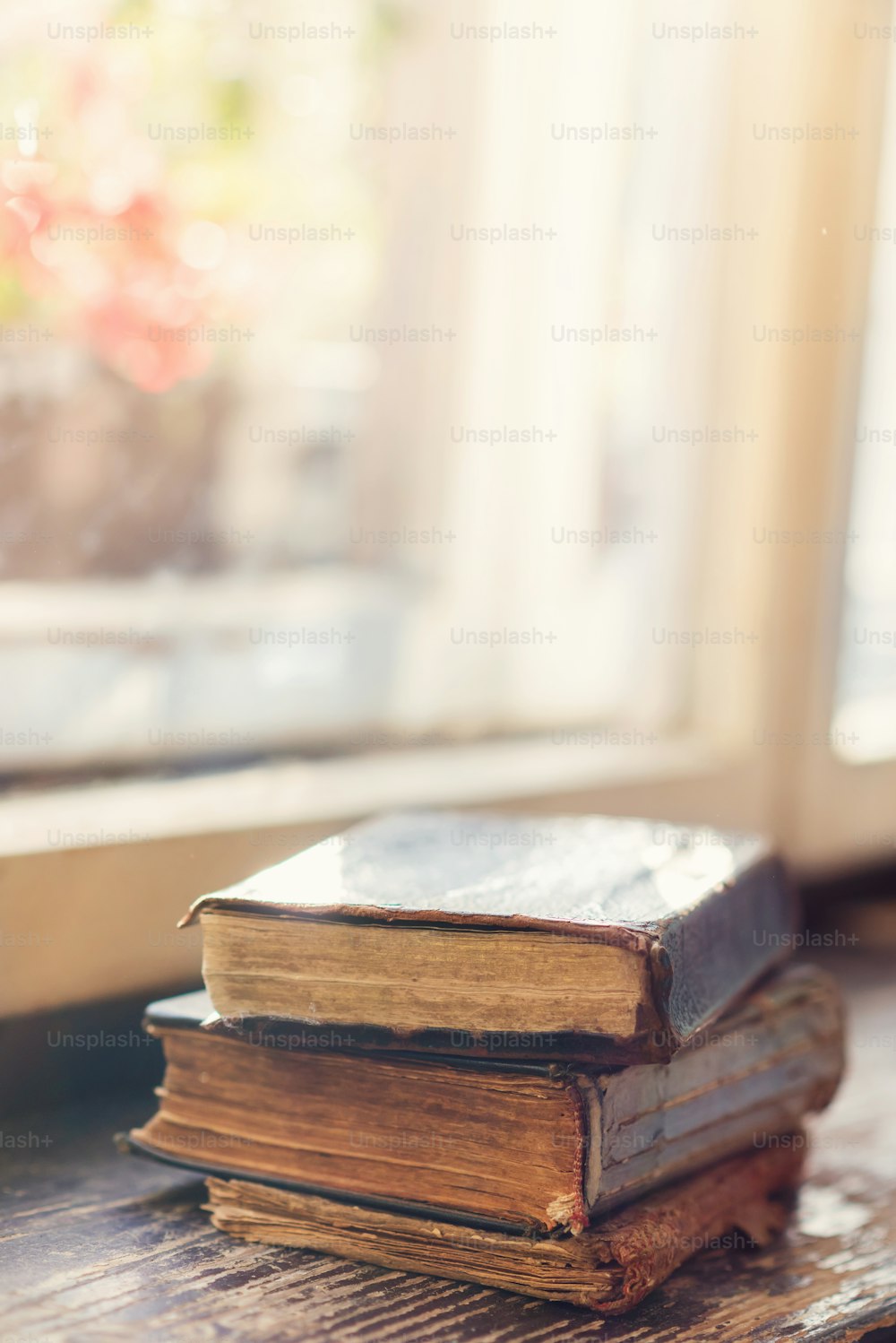 Stack of old books laid on windowsill