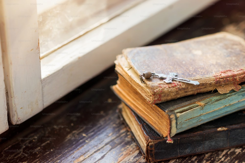 Stack of old books laid on windowsill